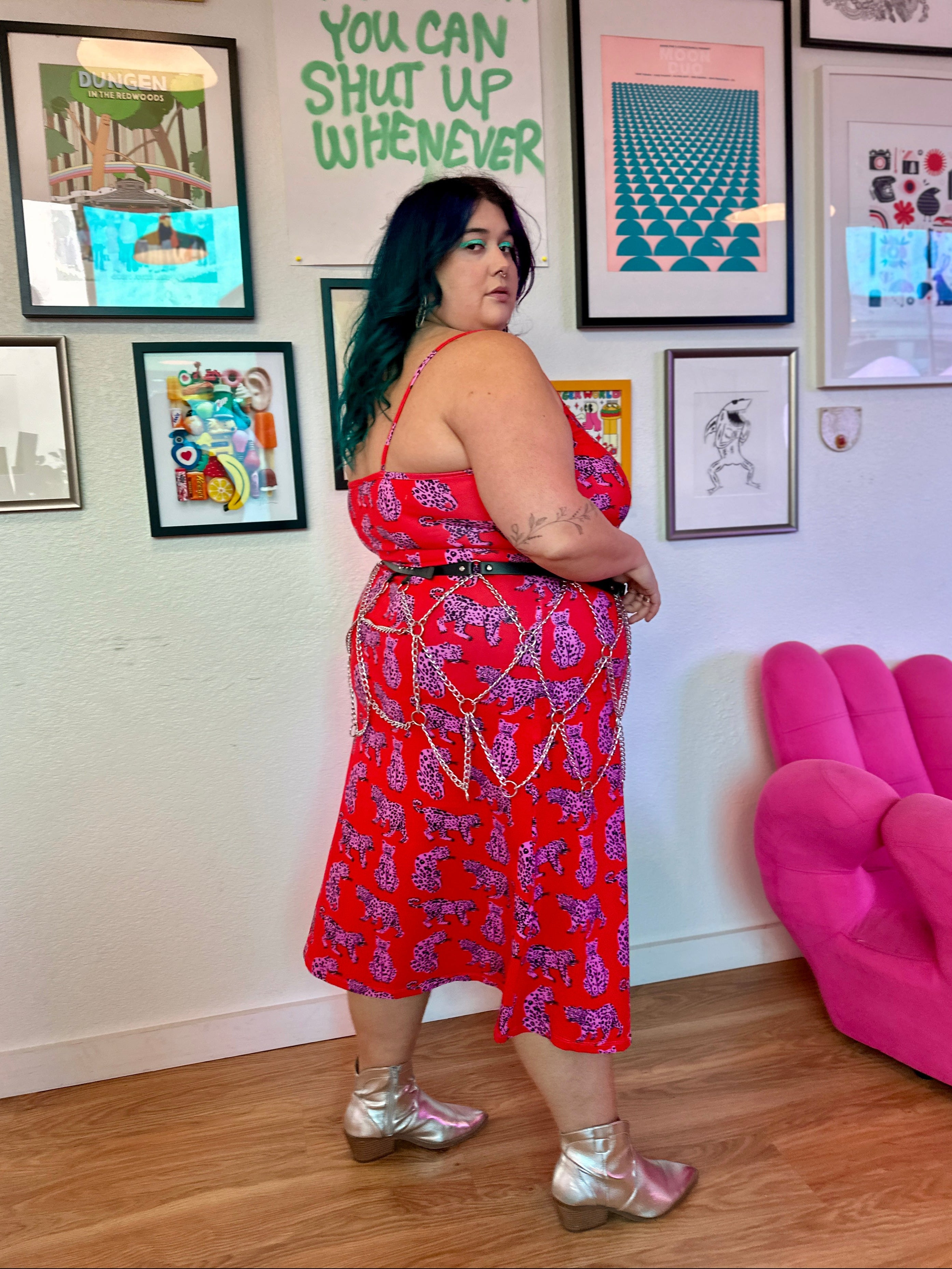 Woman in a red dress standing in a room with colorful artwork on the wall.